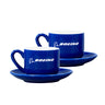 The Boeing Signature Espresso Cup & Saucer Set by BOEING includes two blue espresso cups with matching saucers, each adorned with the iconic Boeing logo in white on the side. Crafted from durable white stoneware, this set is displayed side by side on a white background.