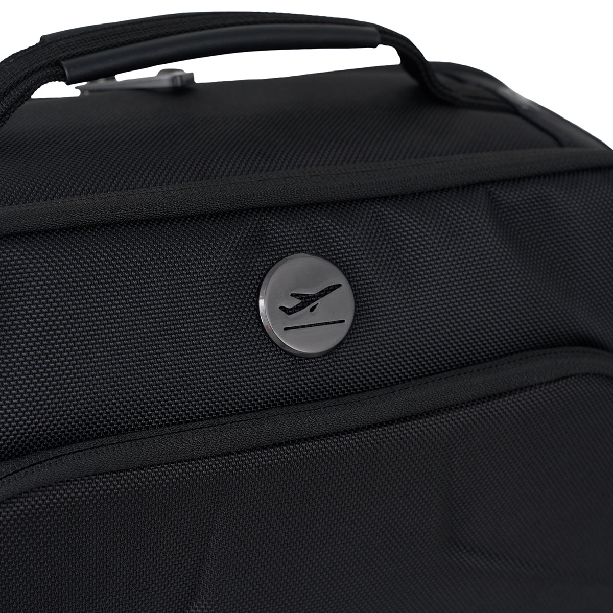 Close-up of a black MyGoFlight Commuter Flight Bag by Boeing, made from ballistic nylon with a silver circular airplane emblem and top handle—ideal for flight commuters.
