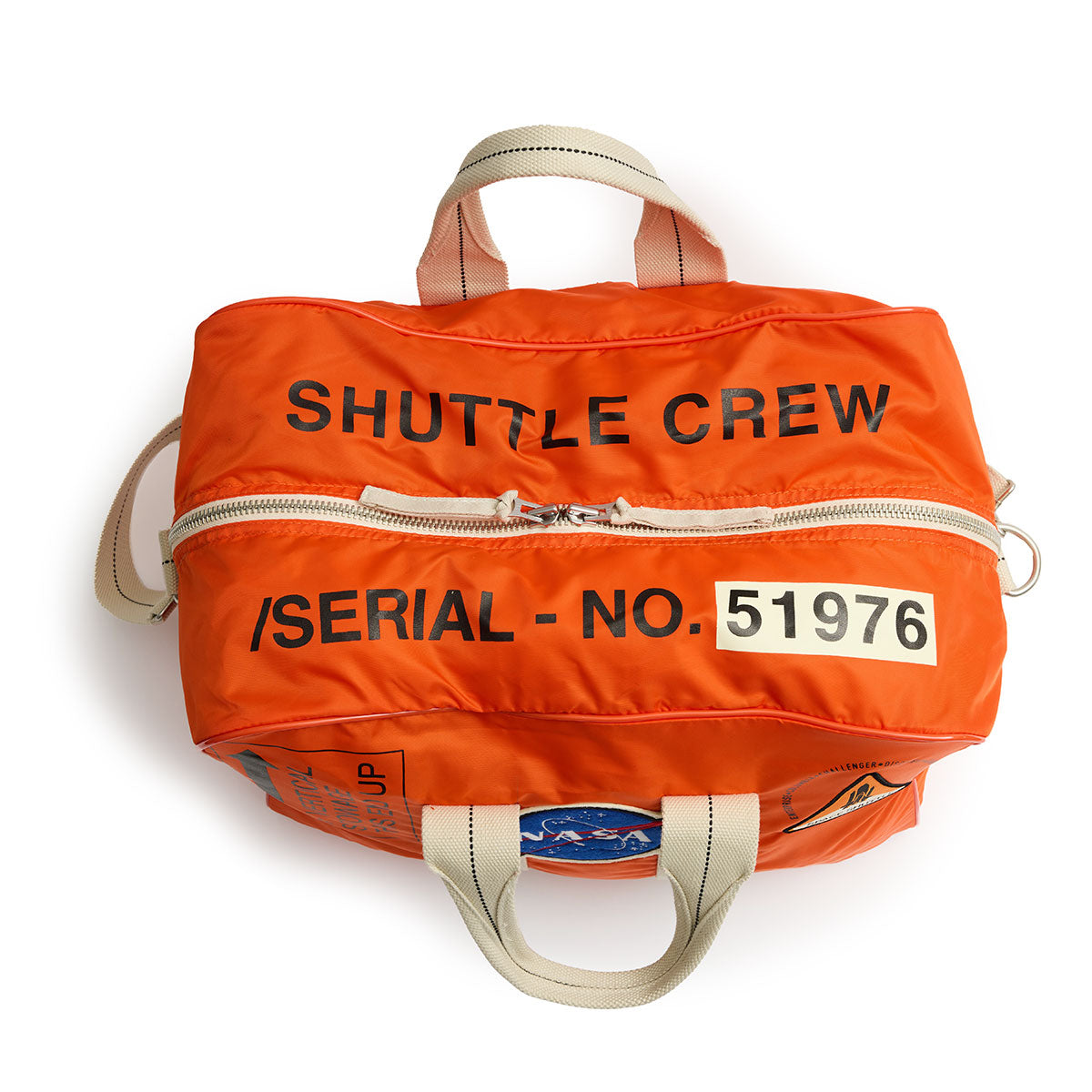 Orange duffel bag with "SHUTTLE CREW" and "SERIAL - NO. 51976" in black text. It features NASA and space shuttle patches, evoking a space exploration theme.
