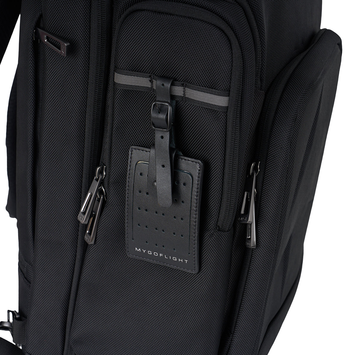 Close-up of the BOEING MyGoFlight Pro Bag, a black ballistic nylon flight bag featuring multiple zippered compartments and a perforated black leather luggage tag—ideal for use as a pilot gear bag.