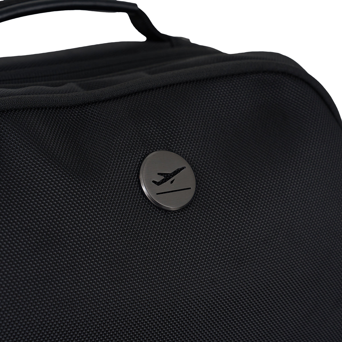 Close-up of the BOEING MyGoFlight Pro Bag in black ballistic nylon, featuring a metallic round emblem with an airplane silhouette.