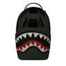 The BOEING Sprayground Boeing AH-64 Apache Sharkmouth DLXSV Backpack is a dark green backpack showcasing a bold, stylized shark mouth graphic with white teeth, red gums, and black accents on the front, inspired by tactical design and aviation heritage.