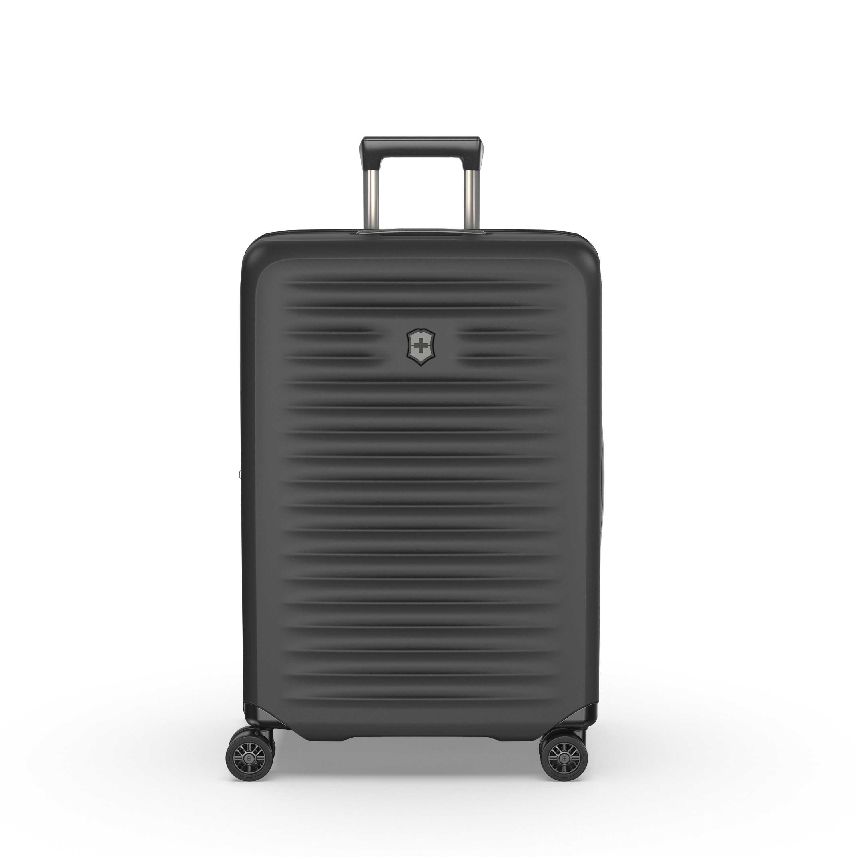 The Victorinox Airox Advanced Medium - Black by VICTORINOX is a sleek suitcase with Swiss engineering, standing on four wheels. It has a textured surface, central emblem below the telescopic handle, and offers a lightweight design for easy handling.