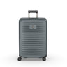 The Victorinox Airox Advanced Medium - Storm by VICTORINOX is a large, gray suitcase with a hard-shell exterior and silver emblem. It features intelligent organization, four black wheels, an adjustable black handle, and horizontal grooves for added texture to its lightweight design.