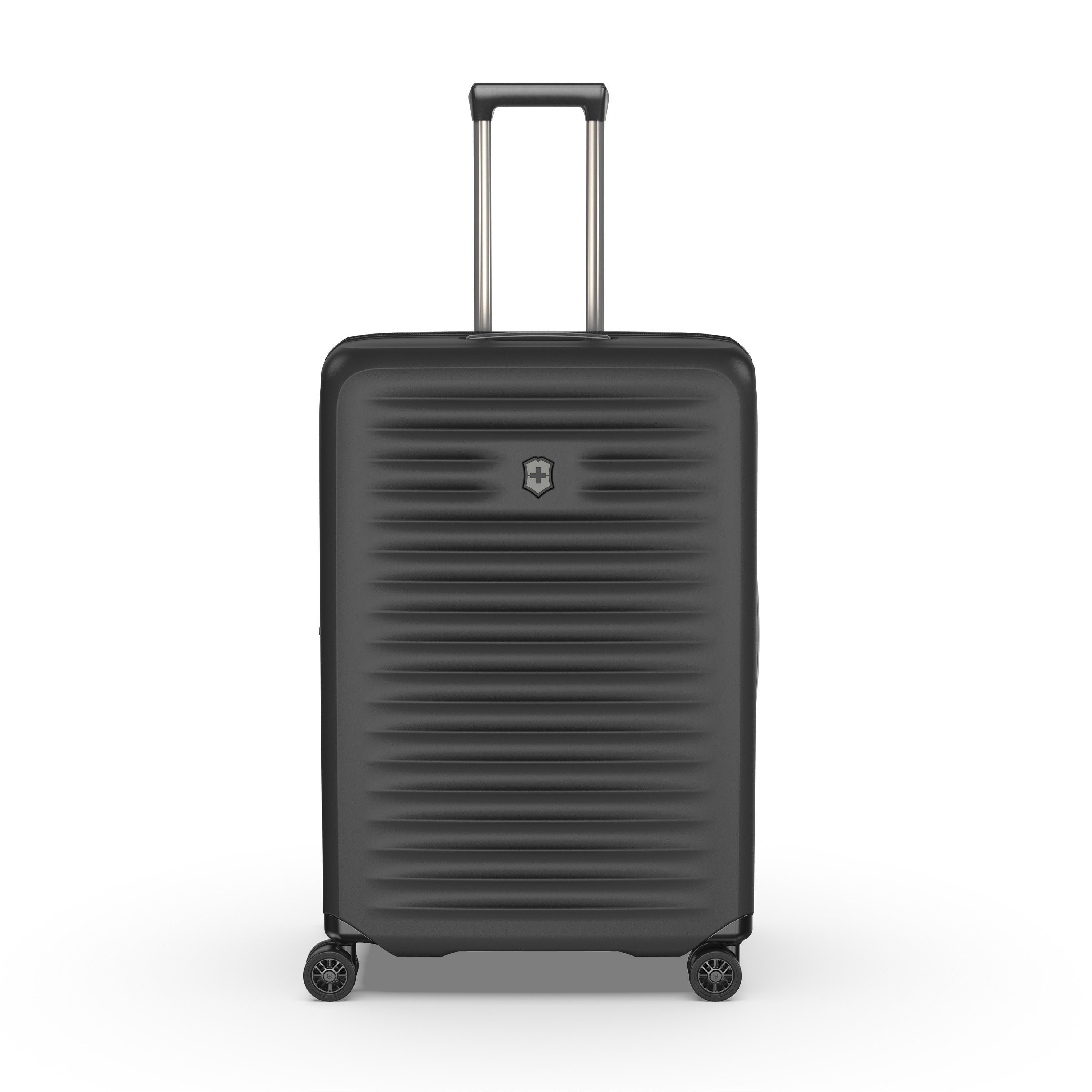 The Victorinox Airox Advanced Large - Black is a Swiss-engineered suitcase featuring four spinner wheels, a telescopic handle, and a textured horizontal ribbed pattern with a subtle emblem on the front.