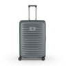 The Victorinox Airox Advanced Large - Storm suitcase features a sleek gray design with ribbed texture, four black wheels, and an extending silver telescopic handle showcasing Swiss engineering. The VICTORINOX logo is on the front center as the lightweight luggage stands upright against a white background.