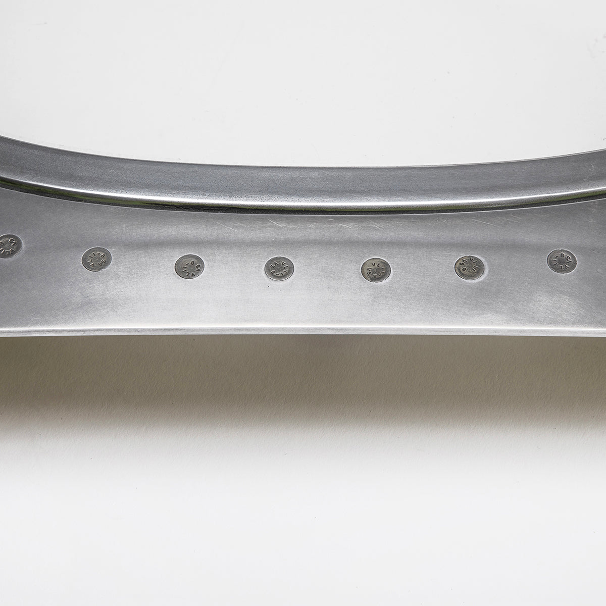 A close-up of the Boeing 777 Natrual Finish Window by Boeing shows its smooth, curved metallic surface with evenly spaced circular indents, resembling an aircraft window frame against a plain white background.