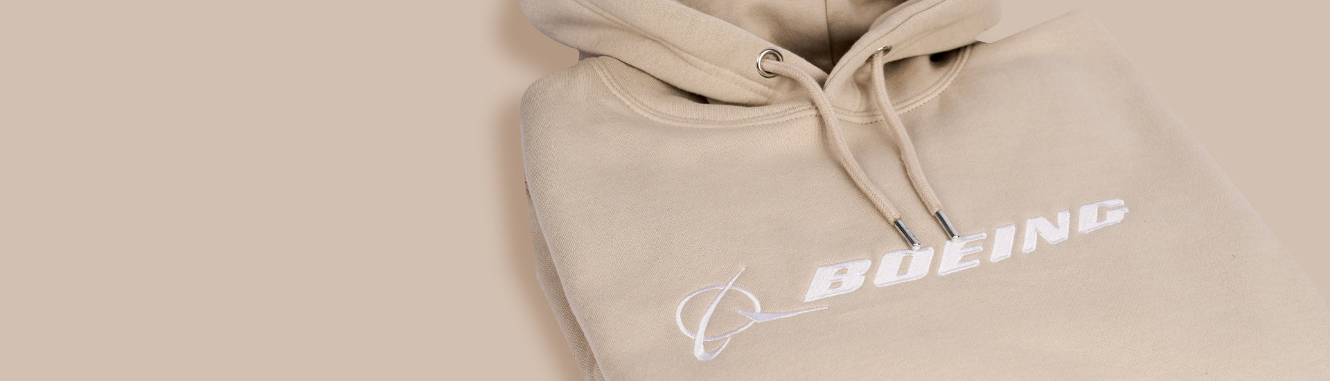 Boeing luxe hooded sweatshirt in beige color. Boeing logo across chest.