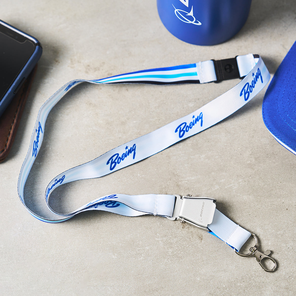 A white lanyard with blue Boeing branding, designed for holding ID badges or keys.