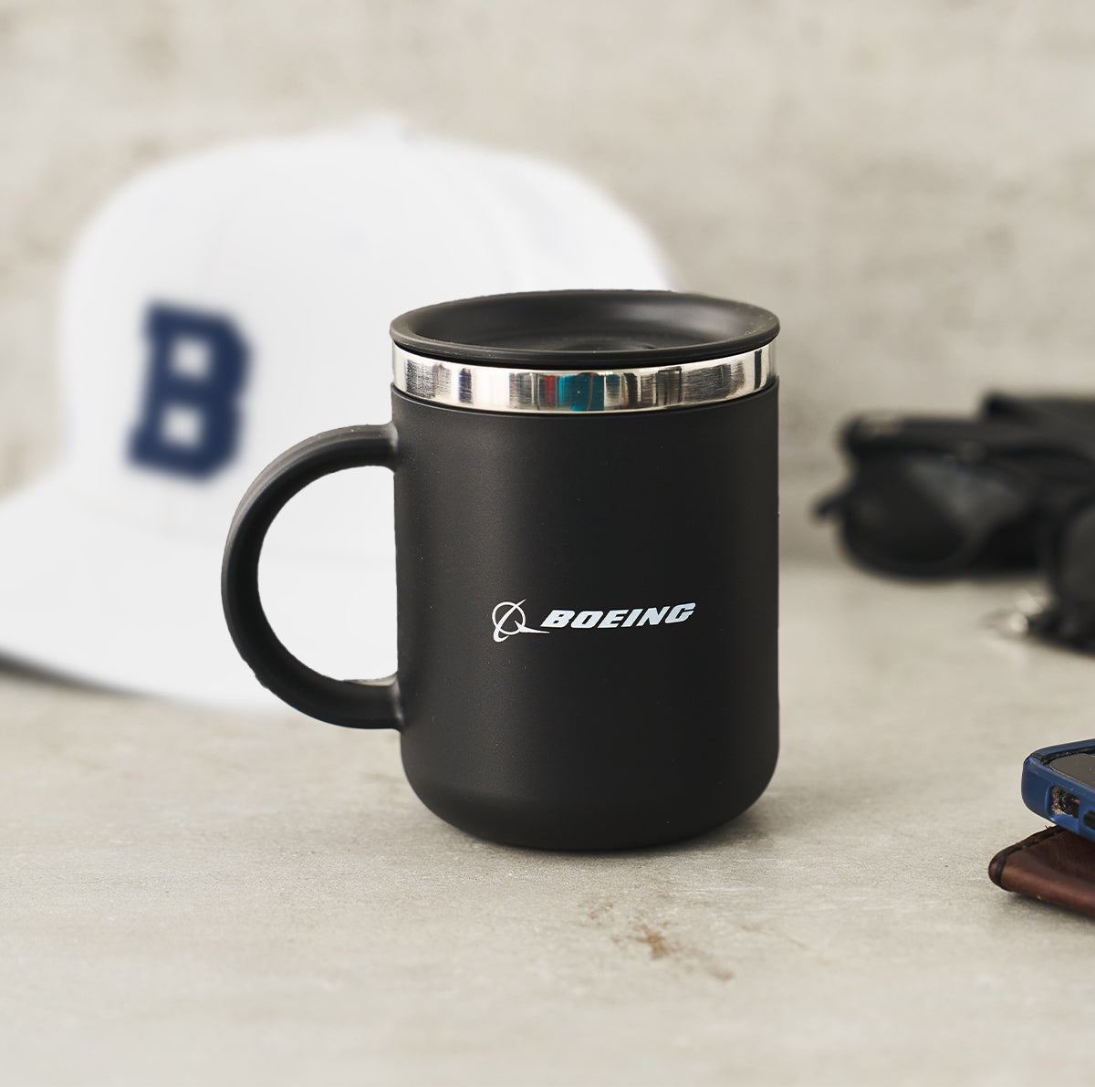 A sleek black Hydroflask mug with a stainless steel rim, featuring the Boeing logo.