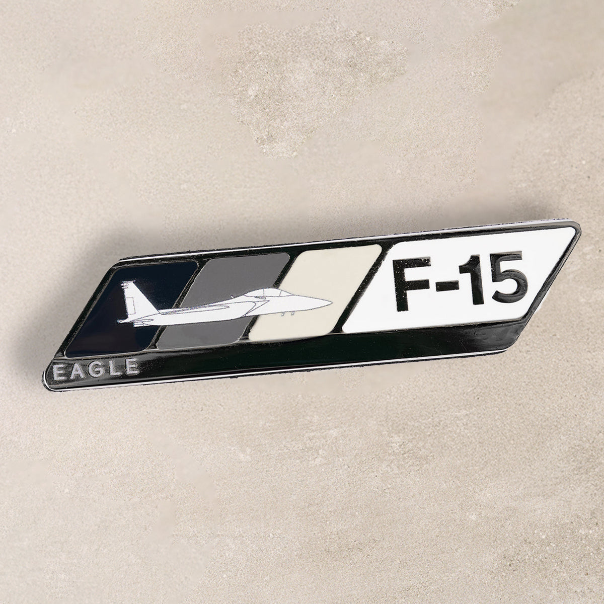 A stylish pin featuring the F-15 Eagle aircraft design, with a combination of colors and textures.