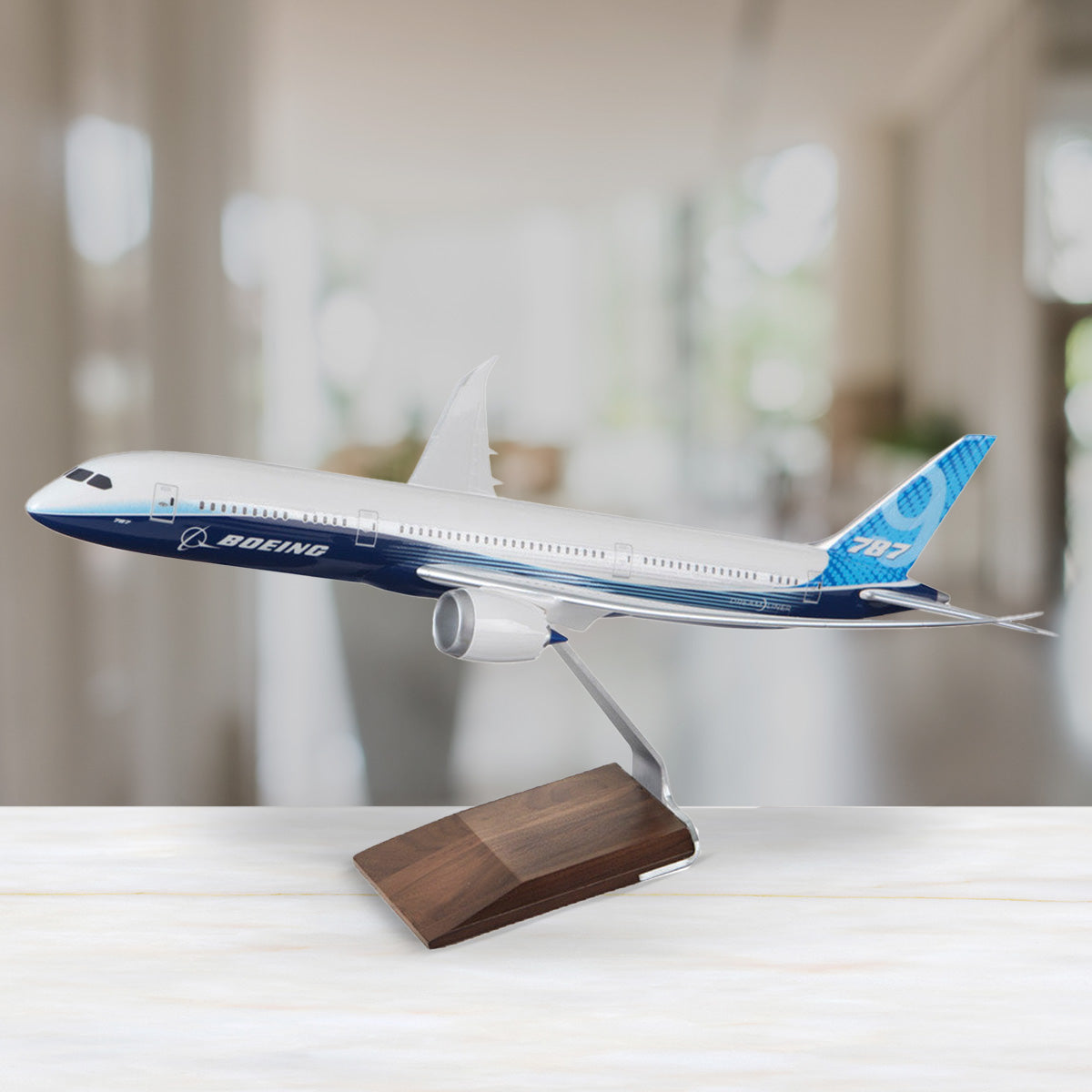 Mosaic large tile featuring a Boeing 787-9 model airplane on office desk with a blurred background. Links to Boeing Models collection page.