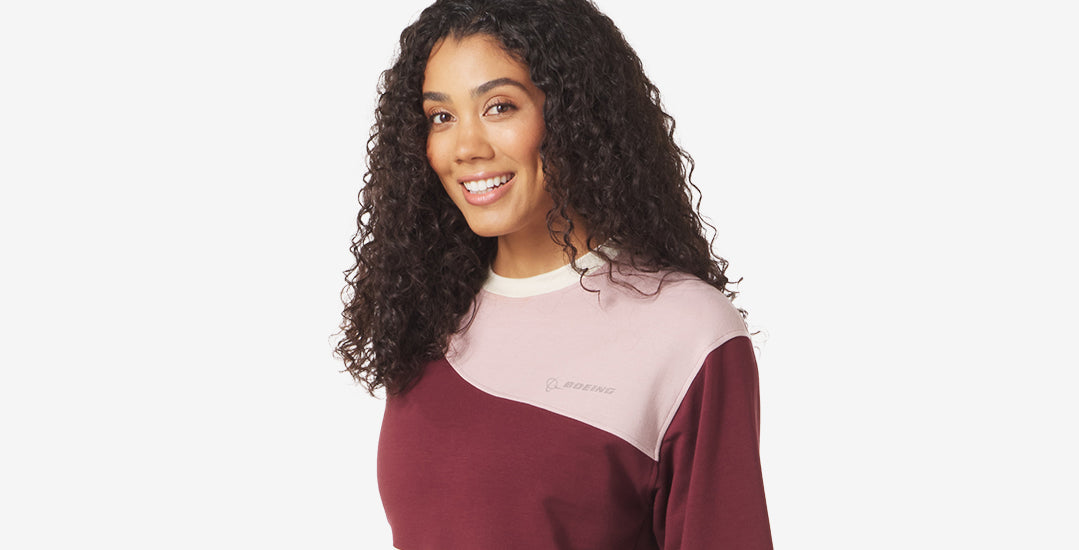 A stylish women's sweatshirt in maroon and pink, featuring a subtle Boeing logo.