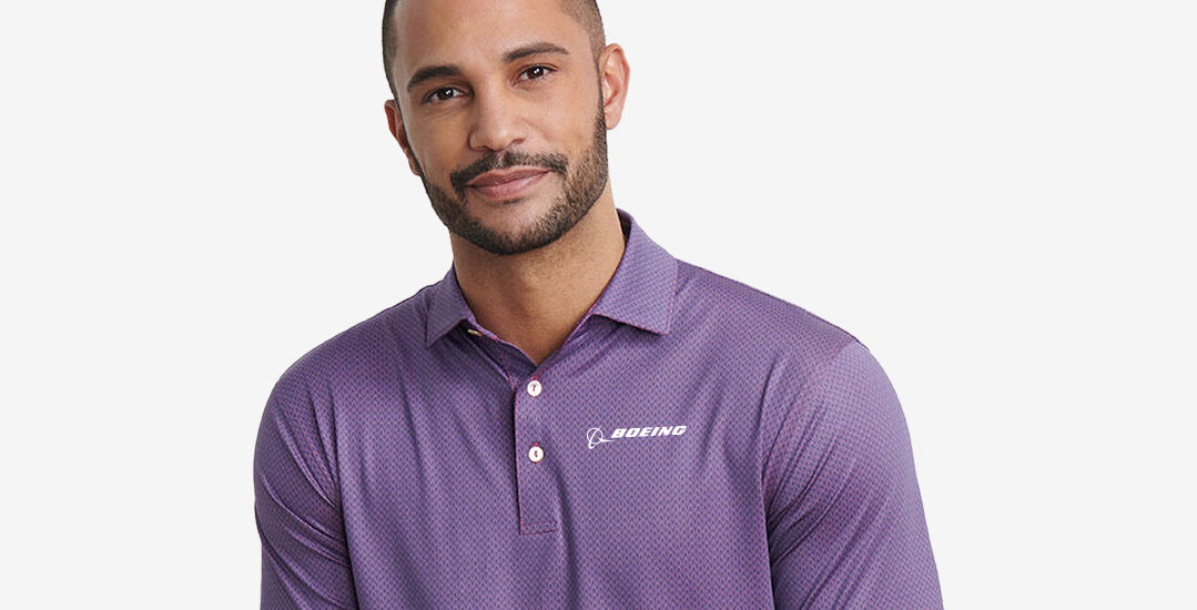 A person wearing a purple polo shirt with the Boeing logo, set against a light grey background.