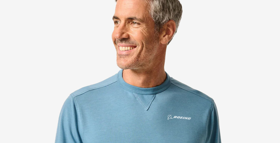 Man wearing a blue crewneck with Boeing logo on left chest.