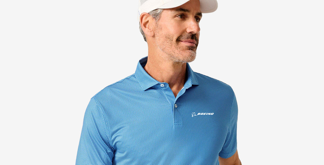 Man wearing a blue polo shirt featuring the Boeing logo, on a light grey background.