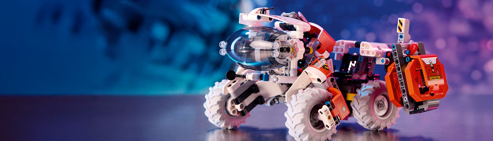 Desktop hero banner for STEM Toys featuring the LEGO Surface Space Loader building set on a blurred purple background. Links to the STEM Toys collection page.