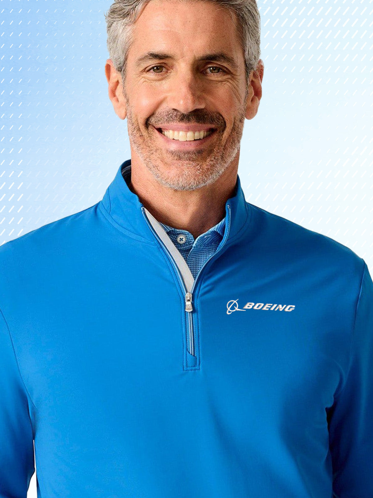 Man wearing a blue Boeing branded pullover against a light blue gradient background