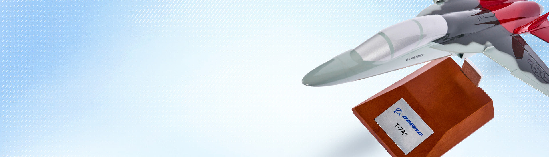 Model Boeing T-7A airplane on a wooden base with a blue gradient background
