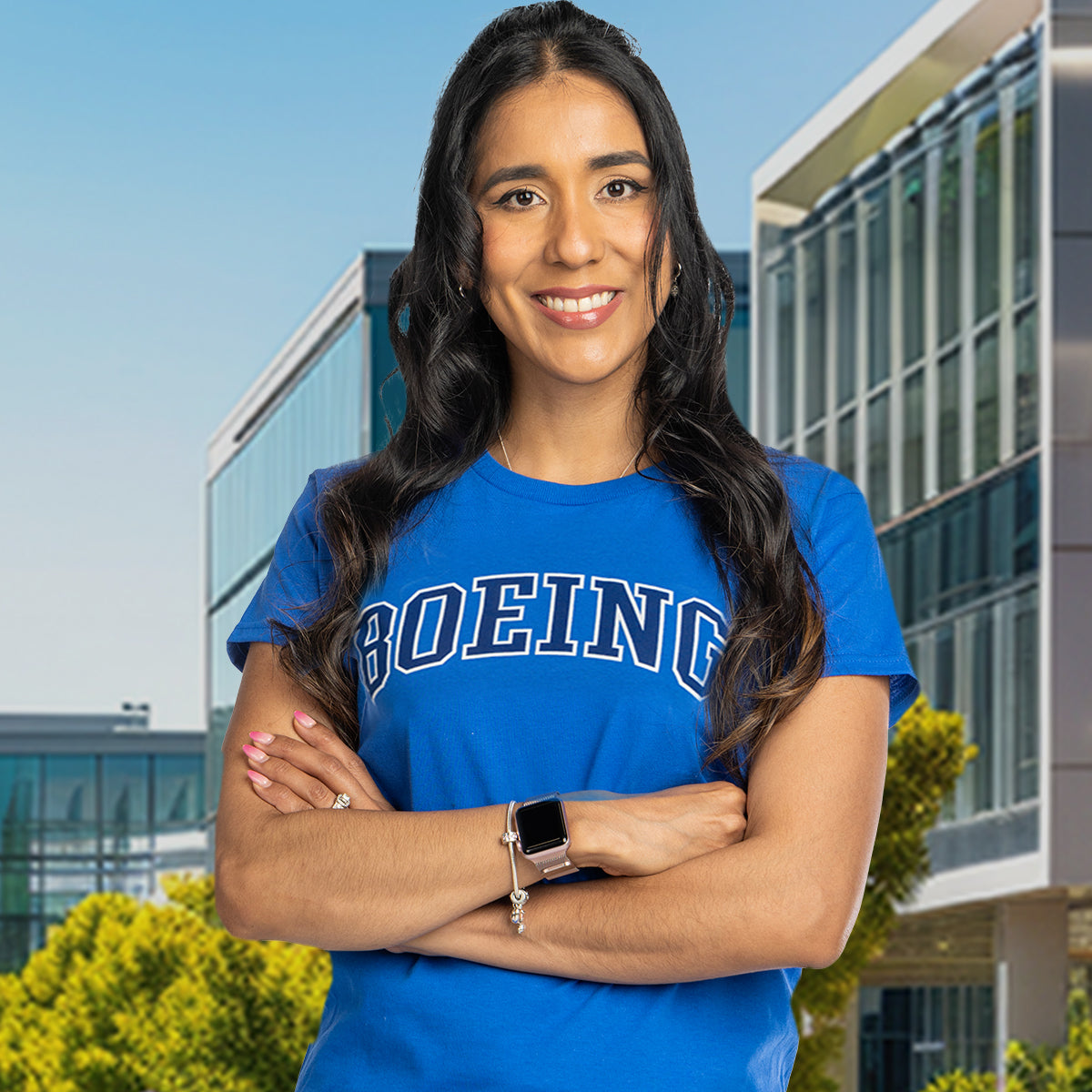 A female model wearing a blue Boeing t-shirt stands outdoors with a modern building and greenery in the background.