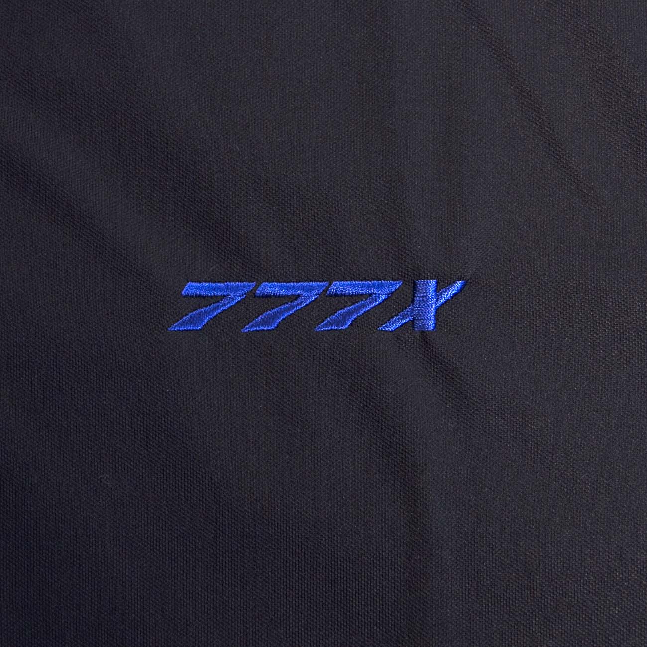 The Boeing Stores 777X Polo is a black moisture-wicking shirt with 777X embroidered in blue, ideal for showcasing your interest in the Boeing program.