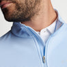 Close up on the zipper of the quarter-zip shown on a male model.