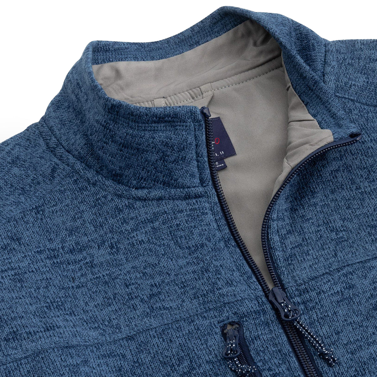 A detailed view of the johnnie-O Boeing Mens Wes Fleece Vest from The Boeing Store shows a textured blue knit with a high collar, slightly unzipped to reveal a beige lining, black label, and zipper pull. Its on clearance with no returns policy.