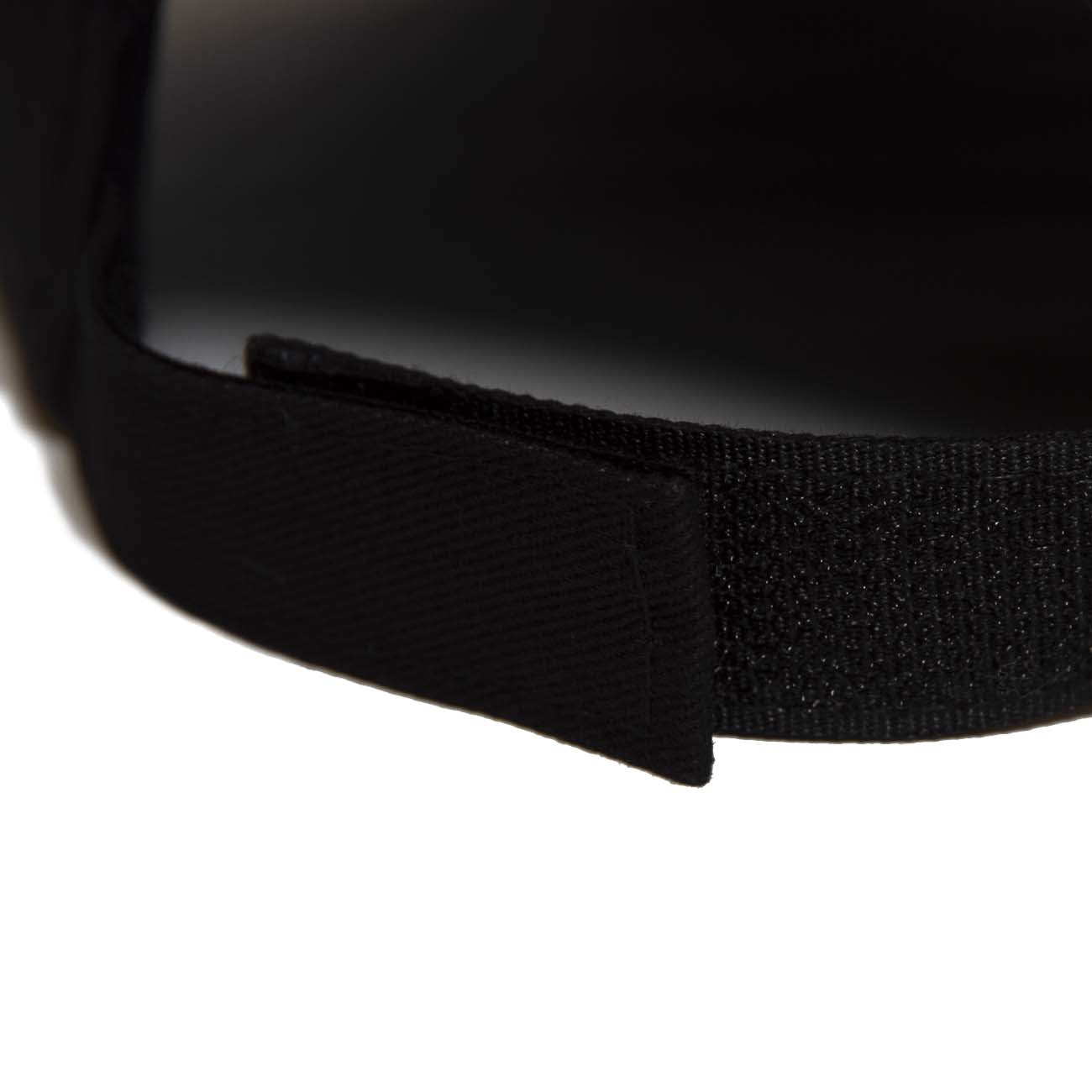 Close-up of the adjustable strap on the Boeing F/A-18 Hat by The Boeing Store, a black 100% cotton baseball cap with Velcro fastening. A perfect wardrobe accessory displayed on a white background.