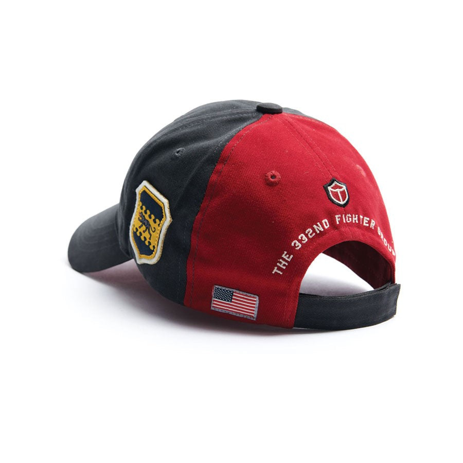 The Boeing Stores Red Canoe Boeing Tuskegee Red Tails Hat is a black and red cap with a small shield emblem, embroidered THE 332ND FIGHTER SQUADRON, and an American flag patch, honoring the legendary Tuskegee Airmen, the Red Tails. The brim is black.