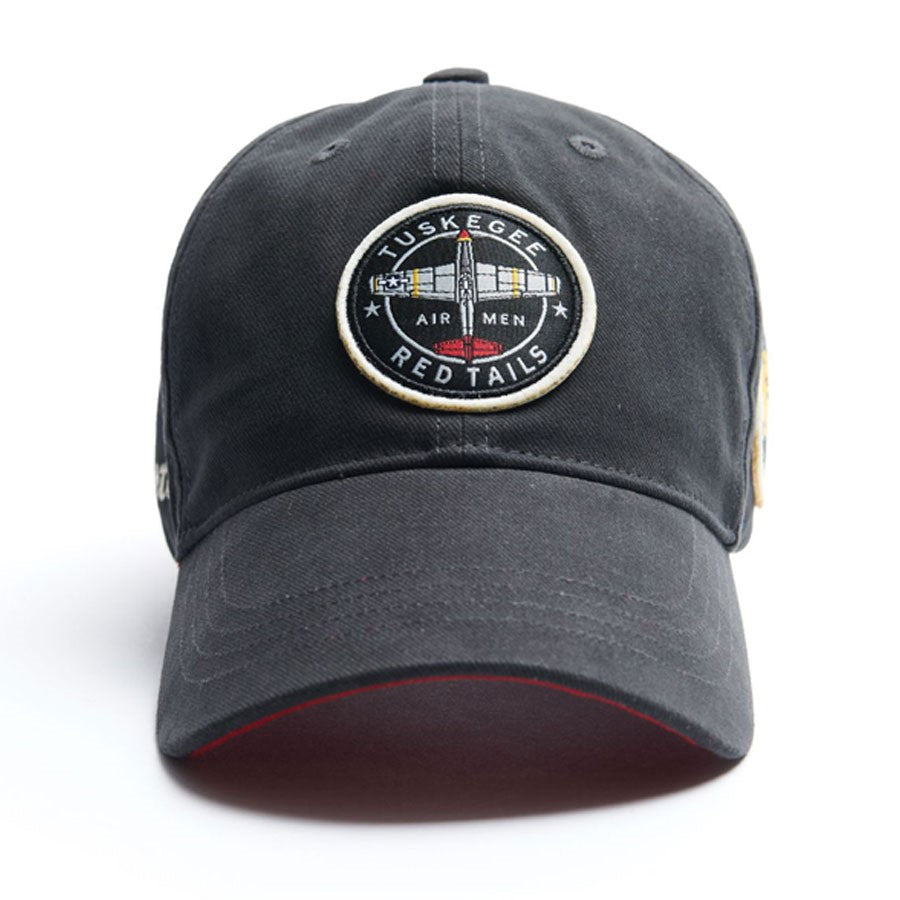 The Boeing Stores Red Canoe Tuskegee Red Tails Hat is a black cap featuring a Tuskegee Airmen Red Tails patch with a P-51 Mustang graphic and a red underside brim.