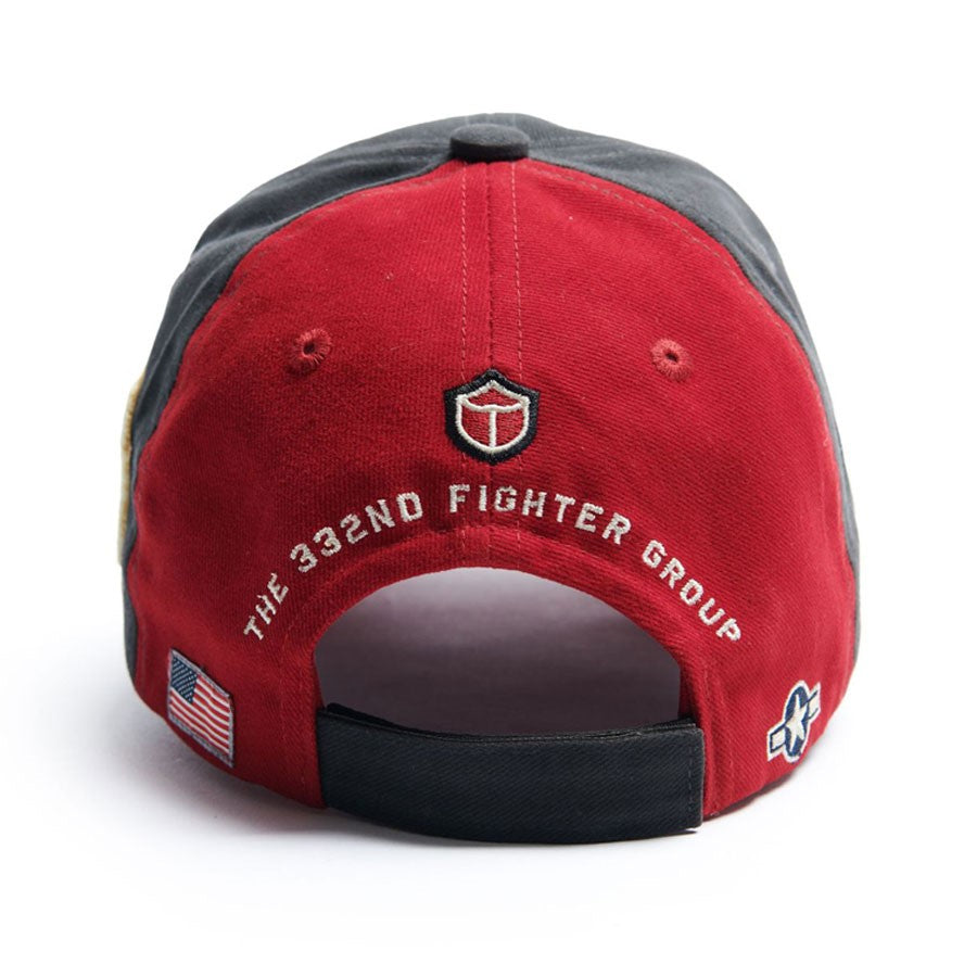 The Boeing Stores Red Canoe Tuskegee Red Tails Hat, in red and gray, features The 332nd Fighter Group text and an emblem at the back. With an American flag and insignia on the sides, it honors the Tuskegee Airmens legacy as P-51 Mustang pilots.