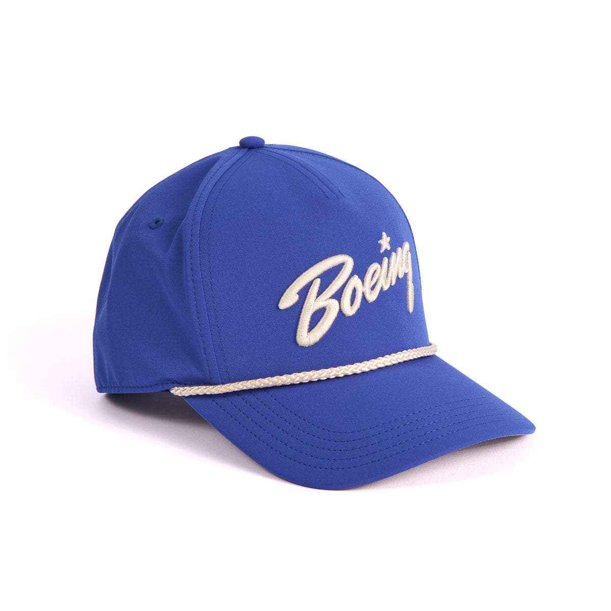 The Boeing 5 Panel Nylon Hat by The Boeing Store is a blue cap with the beige embroidered Boeing script logo on the front and a decorative beige nylon cord across the brims base. It features an adjustable snapback closure set against a white background.