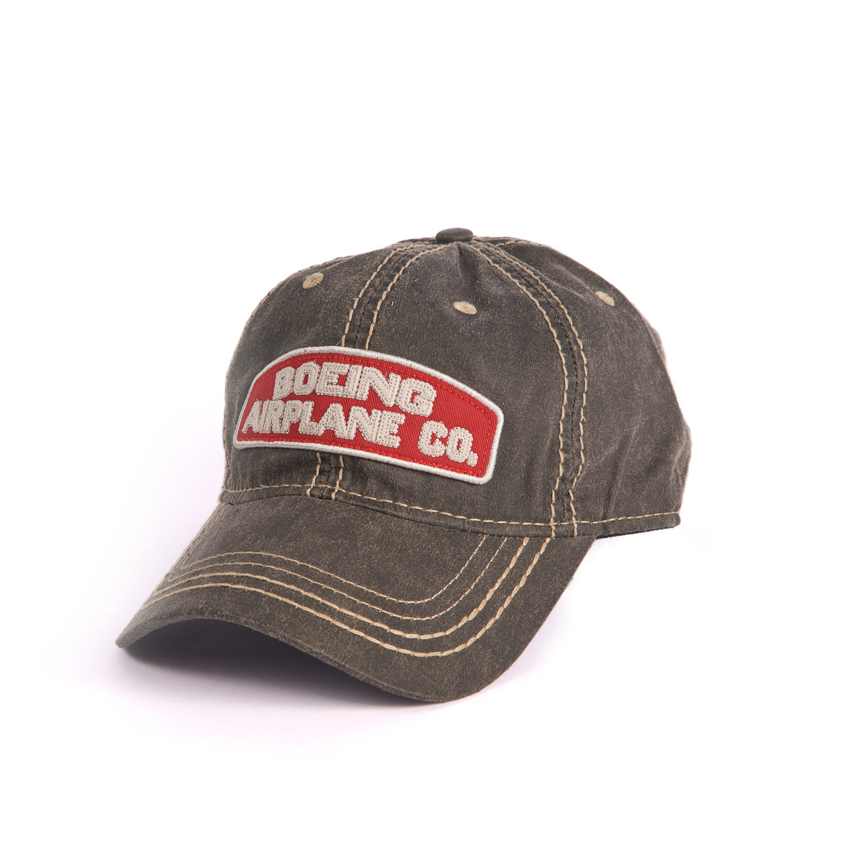 The Boeing Stores Boeing Airplane Co. Heritage Hat is an olive-green baseball cap with white stitching, featuring an embroidered red patch with white text. It has an adjustable velcro strap for comfort.