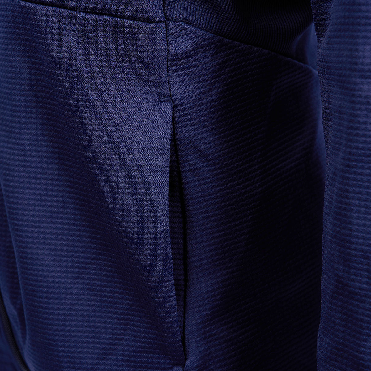 A textured navy fabric with seam and pocket detail showcases The Boeing Stores style in the Callaway Boeing Womens Full-Zip Waffle Fleece, featuring a slightly shiny surface hinting at synthetic or blended material perfect for outdoor adventures.