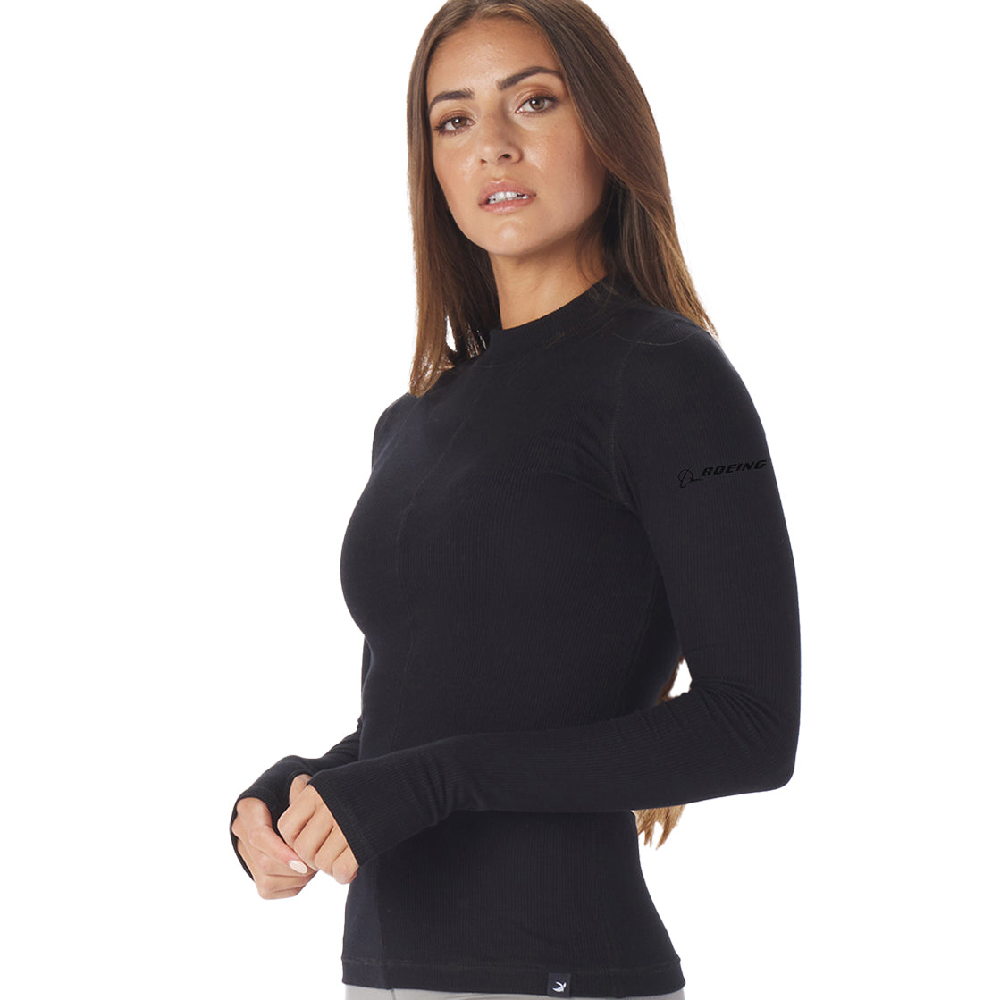 A person with long hair wears the Glyder Boeing Womens Ruby Mock-Neck Long-Sleeve by The Boeing Store, featuring a small logo on the sleeve, while standing against a plain white background.