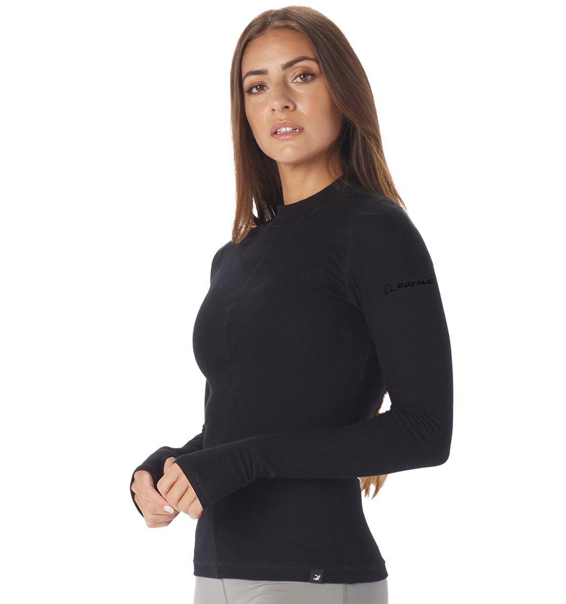 A person with long hair wears the Glyder Boeing Womens Ruby Mock-Neck Long-Sleeve by The Boeing Store, featuring a small logo on the sleeve, while standing against a plain white background.