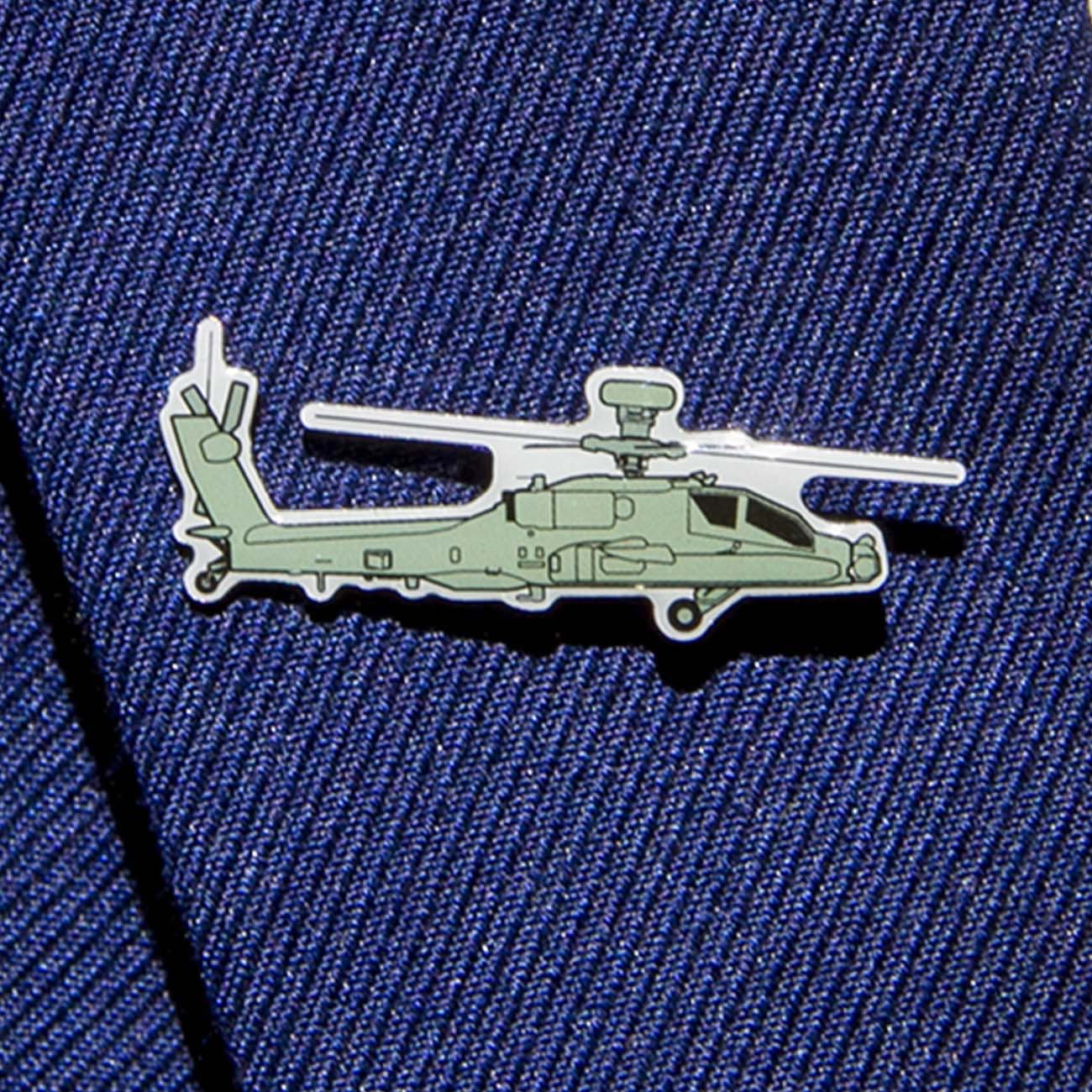The Boeing Stores Boeing Illustrated AH-64 Lapel Pin, in silver tone with a green helicopter design, adorns a blue textured fabric background, exuding elegance and style.