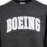 Close up the crewneck sweater in a heather charcoal color.   White Boeing varsity logo across the chest
