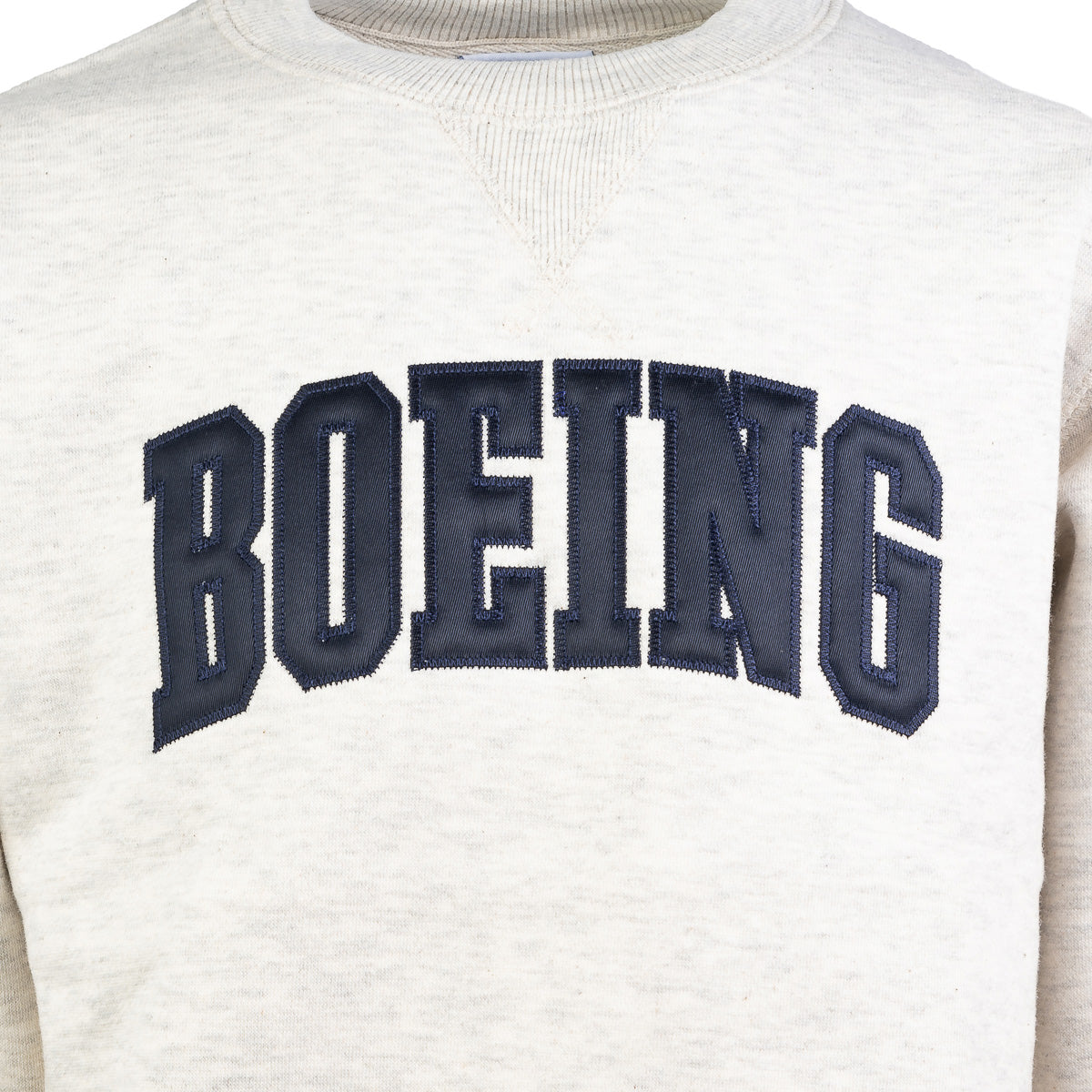 Close up image the crewneck sweater in oatmeal color.  Navy blue Boeing varsity logo across the chest