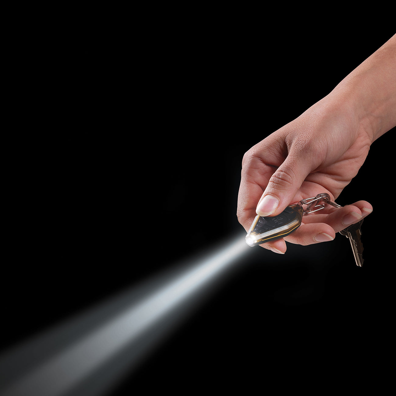 A hand holds a compact lighting solution, with The Boeing Stores Nite Ize Radiant Rechargeable Microlight attached to a keychain, its bright beam slicing through the dark.