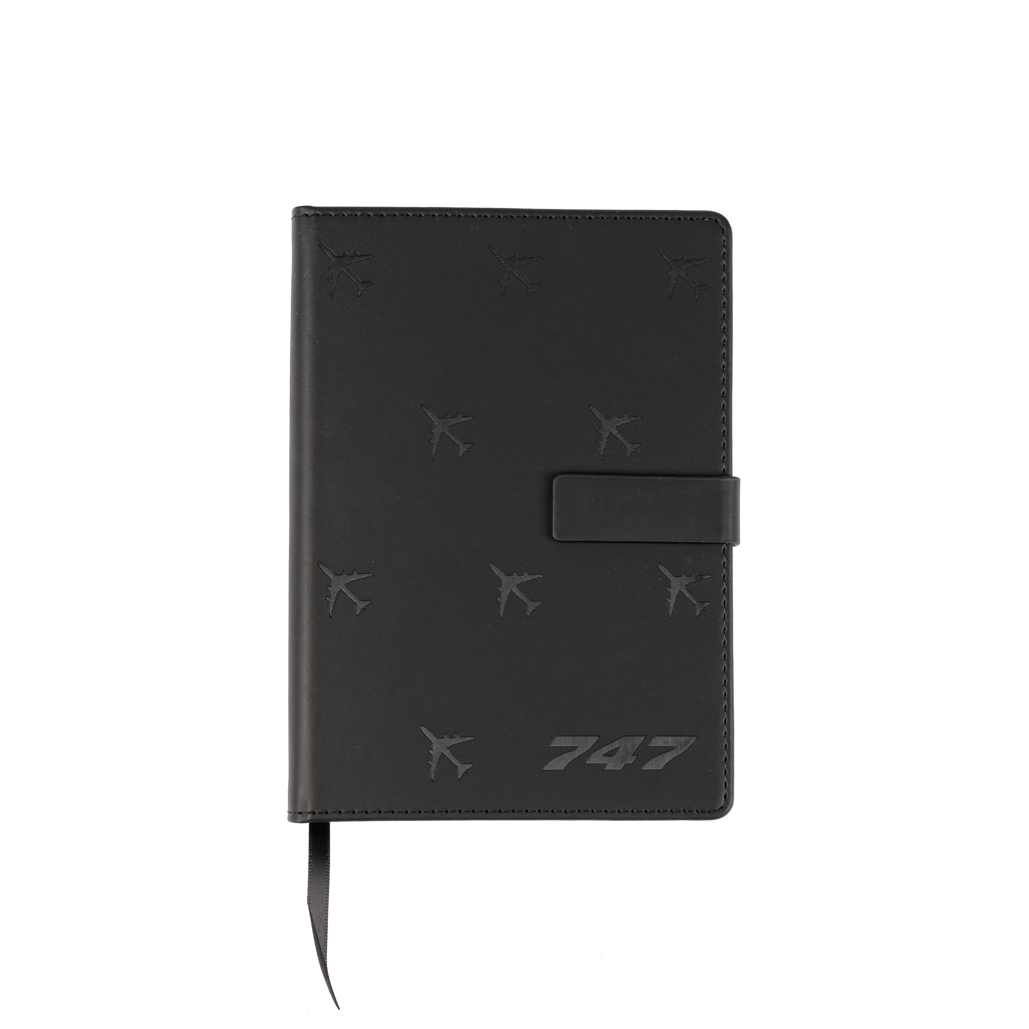The Boeing Store’s black Boeing 747 Notebook features a PU hardcover, strap closure, embossed aircraft silhouettes, and silver “747” on the lower right. A black ribbon bookmark extends from the bottom.