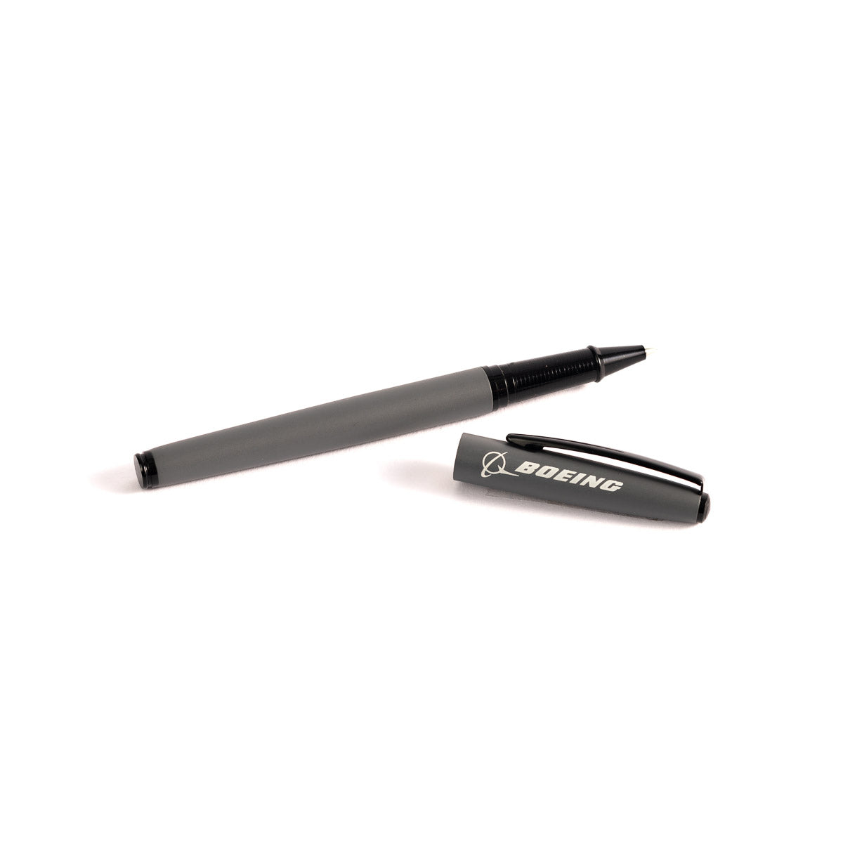 A Boeing Matte Rollerball Pen by The Boeing Store lies on a white background, featuring a gray cap with the company logo and name in white. With its sleek, tapered design, this executive pen exudes elegance and offers both style and precision.