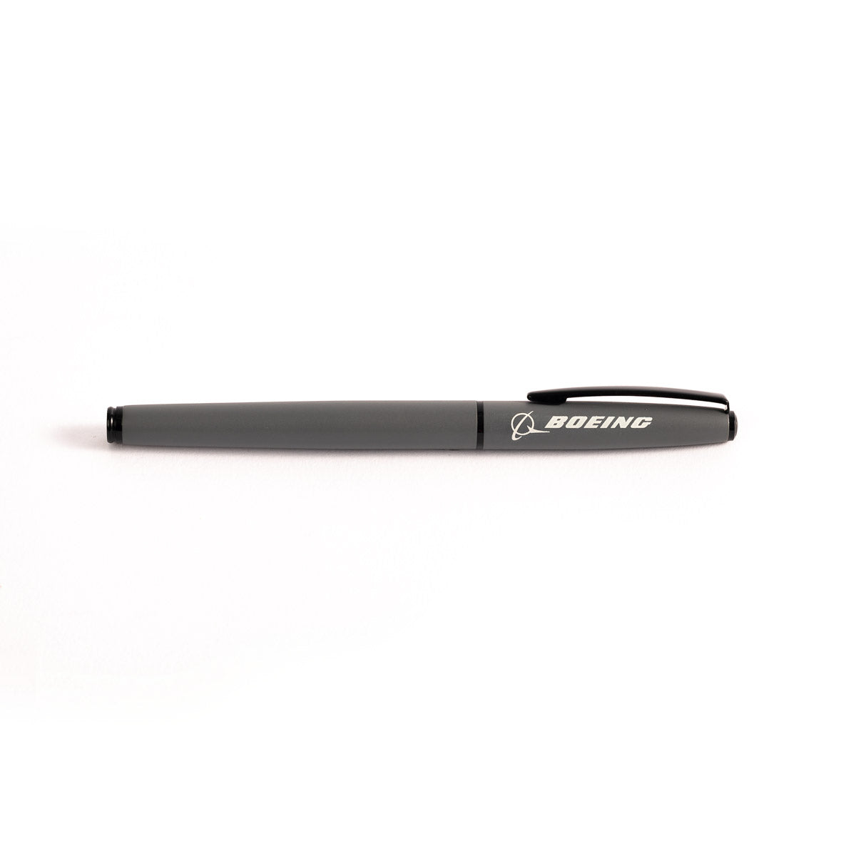 The Boeing Stores executive black rollerball pen, named Boeing Matte Rollerball Pen With Cap, features Boeing elegantly printed in white on the cap and includes a clip. This sleek aluminum metal pen is set against a plain white background.