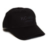 The Boeing Stores Boeing KC-46 Hat is a black, 100% cotton baseball cap featuring KC-46A PEGASUS embroidered on the front in dark gray. It has a mid-profile curved brim and six stitched ventilation holes for comfort.