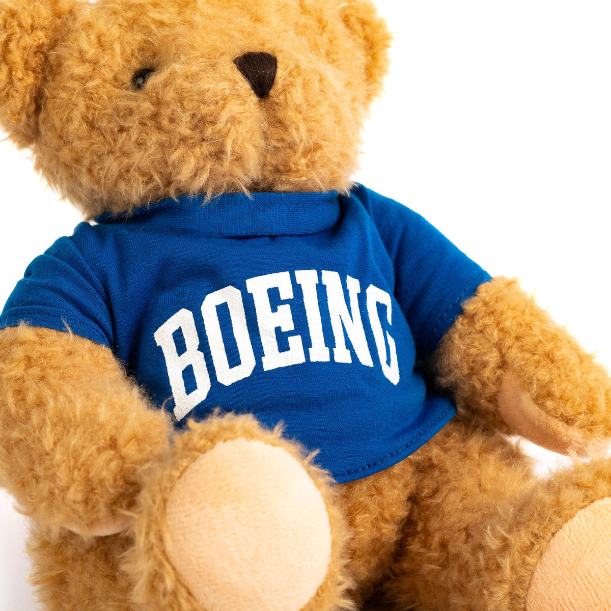 Close up of the Golden fur bear wearing royal t-shirt with white Boeing varsity logo across the chest.