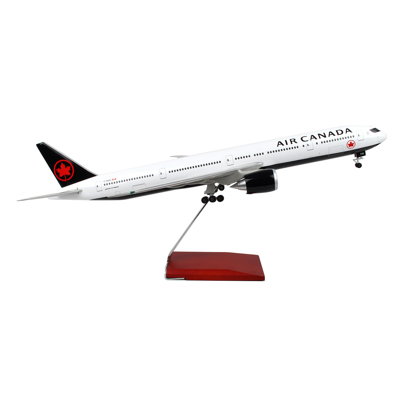 The Daron Air Canada Boeing 777-300 1:100 Model airplane, crafted from injection molded plastic, showcases authentic markings with the airline’s logo on its tail. The model is white and positioned at a slight upward angle on a stand.