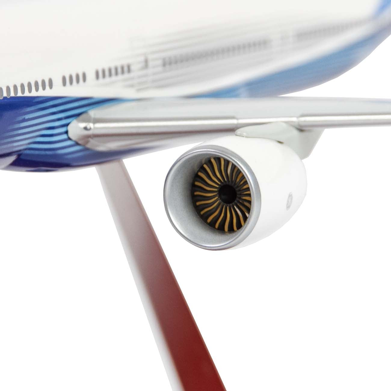 Close-up of The Boeing Store’s Boeing Unified 777-300ER 1:200 Snap Model, highlighting intricate jet engine fan blades, wing detail, and the blue-and-white fuselage on a display stand.
