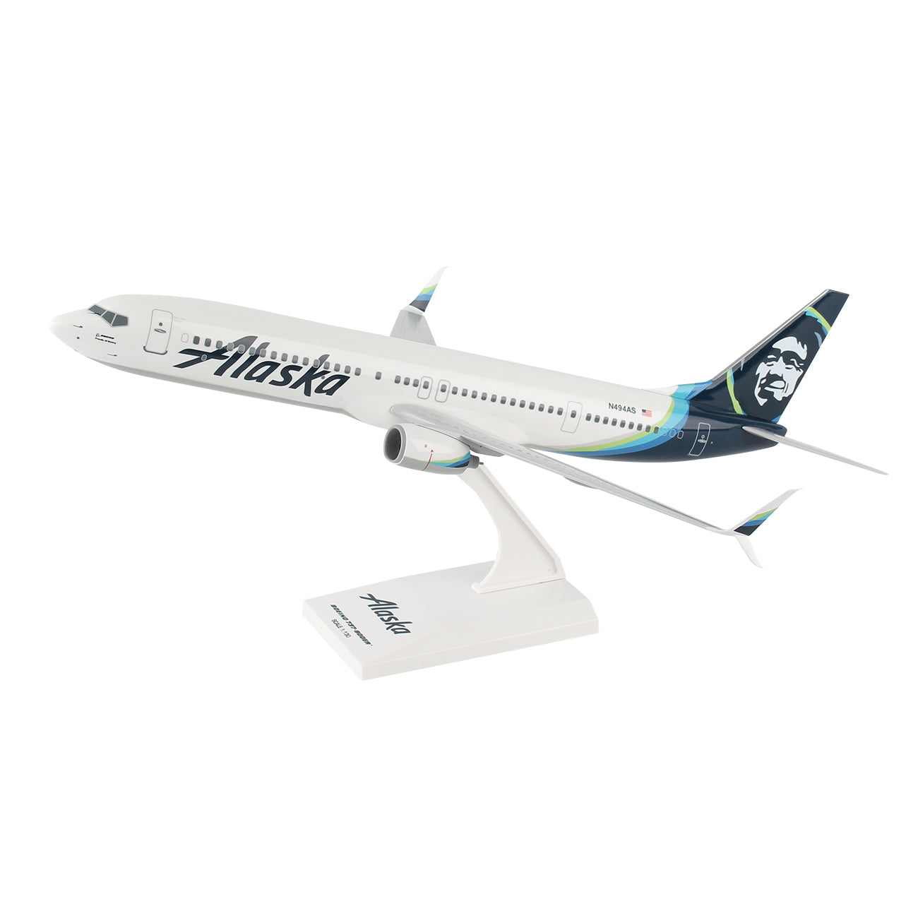 The Daron Alaska Airlines Boeing 737-900ER 1:130 Model features detailed graphics, including the airlines logo and a stylized face on the tail fin, and is displayed mounted on a white stand against a plain white background.