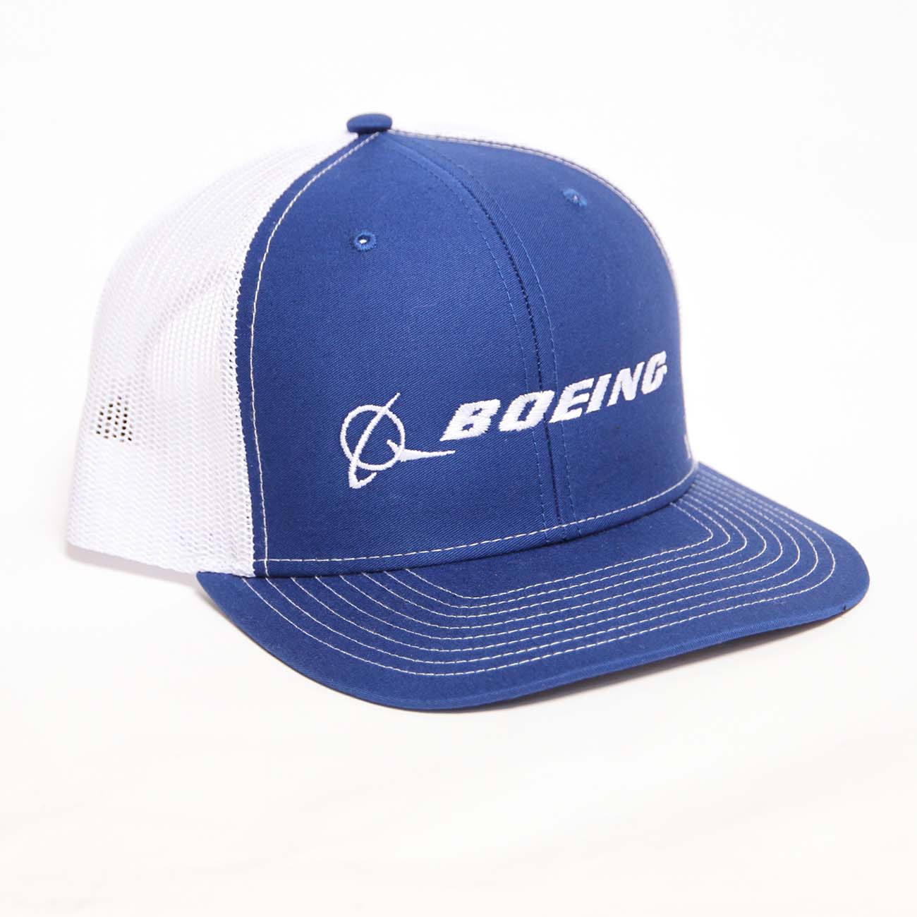 The Boeing Stores Richardson Trucker Hat features a blue front with the Boeing signature logo in white. It has white mesh back, blue brim, a snapback closure for an adjustable fit, and stylish text with an abstract airplane graphic.