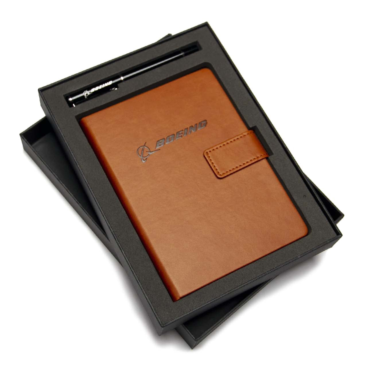 The Boeing Stores Boeing Notebook Pen Set features a brown leather notebook with clasp, logo on the cover, and eco-friendly wood-free paper, all elegantly presented in a black gift box.